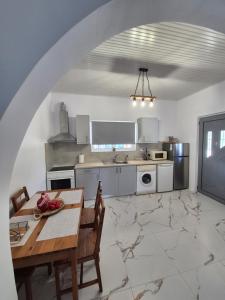 a kitchen with a table and a dining room at Casa di Kontessa in Acharavi