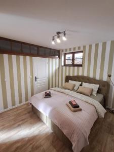 Cama grande en habitación con paredes a rayas en Apartmán Akademik, en Banská Štiavnica