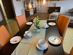 a dining room table with cups and saucers on it at Fewo Naturblick in Wiesenthau