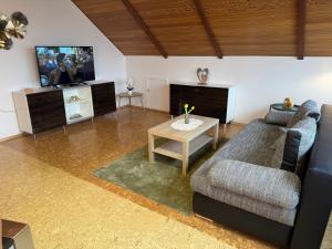 a living room with a couch and a table at Fewo Naturblick in Wiesenthau +6 photos