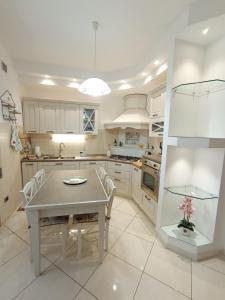 a white kitchen with a table and chairs at Casa Cento in Fossacesia