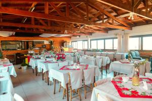 a dining room with white tables and chairs at Oceano Hotel in Torres