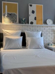 a bedroom with a bed with white sheets and pillows at Divine Studio Fermei 62 in Popeşti-Leordeni
