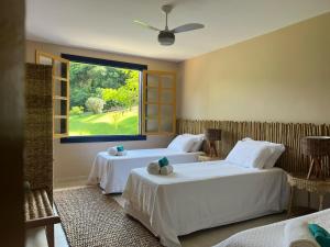 ein Schlafzimmer mit zwei Betten und einem großen Fenster in der Unterkunft Fazenda do Barro CMD Maravilhosa Casa de Fazenda in Conceição do Mato Dentro + 12 Fotos