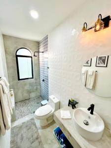 a bathroom with a sink and a toilet and a shower at King Bed, Kitchen, Saltwater Pool, Fast Wifi, Air Conditioning - Flor at Casa Calavera in San Francisco