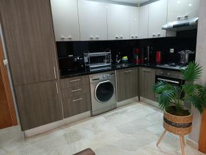 a kitchen with a washing machine and a dishwasher at Residence Touristique La Rambla in Fnidek