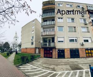an apartment building with a sign on the side of it at Block Home Apartman in Makó