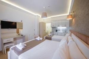 a large white bedroom with two beds and a kitchen at Hotel Mira Mare in Ksamil