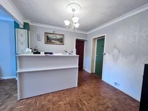 a room with a white counter and a green door at All Seasons Gatwick Guest House & Parking in Horley