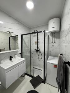 une salle de bain blanche avec une douche et un lavabo dans l'établissement Studio Rio, à Trebinje 22 autres photos