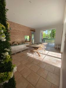 a room with a table and chairs and a brick wall at A Chardonnerets by La Maison de Mel in Enghien