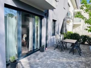 a patio with a table and chairs next to a building at Central Perk Apartman in Balatonalmádi