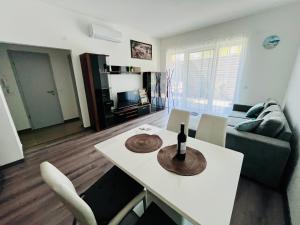 a living room with a table with a bottle of wine on it at Central Perk Apartman in Balatonalmádi