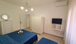 a bedroom with a blue bed and a tv at Lucy Apartment sul lungomare in Maiori +8 photos
