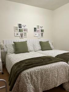 a bedroom with a bed with a blanket and pictures on the wall at Casa Palafox Fitero in Fitero