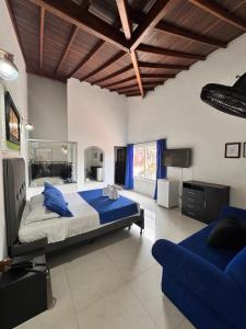 a bedroom with a large bed and a blue couch at Hotel Premium BISS in Supía