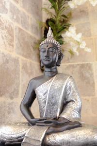 uma estátua de um Buda com uma coroa na cabeça em Hotel Le Centre em Gramat