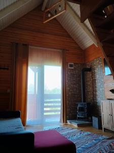 a living room with a large window and a fireplace at Tiny H in Ocnele Mari