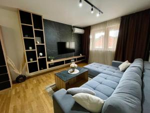 a living room with a blue couch and a television at MAR Residence 15 in Niš