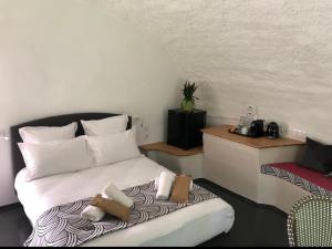 a bedroom with a bed and a table and a chair at Motel l'eau vive in Raon-lʼÉtape