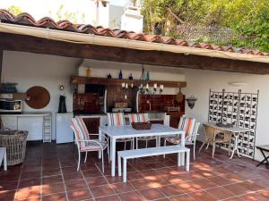 a patio with a table and chairs and a kitchen at Villa la Grande Bastide piscine et tennis collectif in Cassis