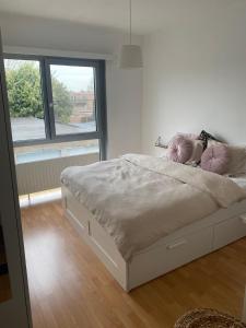 a white bed with pink pillows in a bedroom at Perfect for Tomorrowland in Edegem