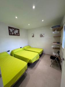 two beds in a room with green sheets at Eucaliptus in Camarles