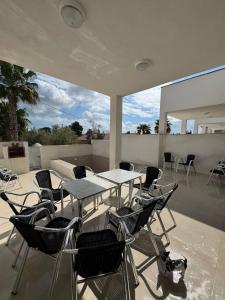 a patio with a table and chairs and a dog sitting on it at Eucaliptus in Camarles
