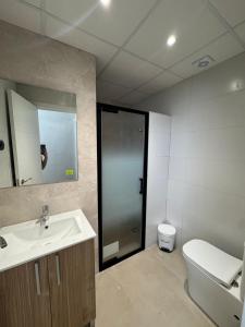 a bathroom with a sink and a toilet and a mirror at Eucaliptus in Camarles +8 photos
