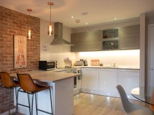 a kitchen with a counter and chairs in it at Lancaster City Apartment in Lancaster