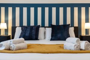 un letto con tre asciugamani piegati sopra e due lampade di Suite Charme Brera a Milano