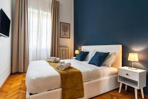 una camera da letto con un letto grande con pareti blu di Suite Charme Brera a Milano