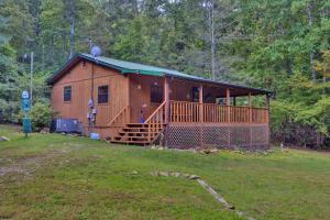 una grande cabina in legno con portico su un campo di Boo Bear Close to Gatlinburg a Cosby