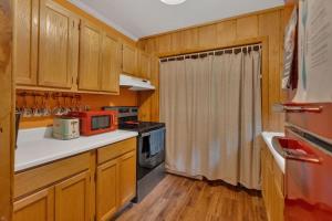una cucina con armadi in legno e forno a microonde rosso di Boo Bear Close to Gatlinburg a Cosby