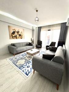 a living room with two couches and a rug at Sevez Apartments & Homes in Gelibolu