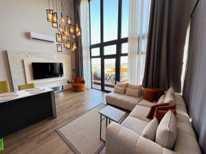 a living room with a couch and a tv at Loft Sabırlı in Kaynarca