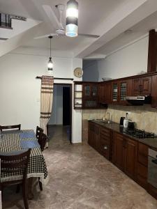 a kitchen with wooden cabinets and a table in it at Colombo Green Heaven in Cotta Road Railroad Station +8 photos