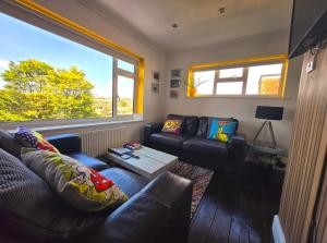 a living room with a couch and a table at 3 Bed House Stunning Views And Free Parking in Rottingdean