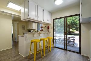 a kitchen with yellow stools and a kitchen with a patio at Sea Change by Paradise Retreats in Santa Barbara