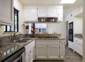 a kitchen with white cabinets and a sink at Sea Change by Paradise Retreats in Santa Barbara