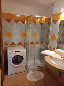 a bathroom with a washing machine and a sink at RoomAntic House in Is Molas  +5 photos