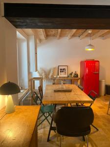 Charmante maison de campagne proche du lac de Paladru في Valencogne: غرفة طعام مع طاولة وثلاجة حمراء +20 صورة