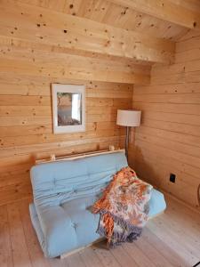 a room with a blue couch in a log cabin at Dzika Warmia- domek bez sąsiadów na Warmii z balią i kominkiem in Glebisko