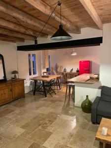 Charmante maison de campagne proche du lac de Paladru في Valencogne: مطبخ وغرفة معيشة مع طاولة وكراسي