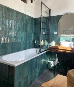 Charmante maison de campagne proche du lac de Paladru في Valencogne: حمام مزود بحوض استحمام ومغسلة ومرآة