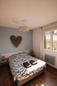 - une chambre avec un lit et un cœur sur le mur dans l'établissement Appartement très calme 2 chambres avec parking et jardin privé sur les hauteurs de Briançon, à Briançon
