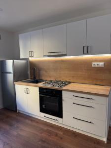 Una cocina con gabinetes blancos y un horno de estufa. en AR OLD TOWN point, en Košice