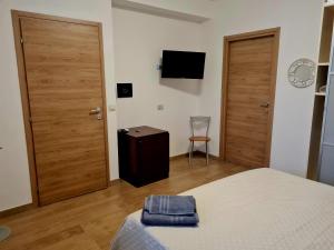 a bedroom with two doors and a bed and a chair at B&b Tre Pandele in Ploaghe