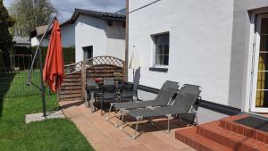 a patio with a table and chairs and an umbrella at Urlaubsapartment am Silbersee in Villach +11 photos
