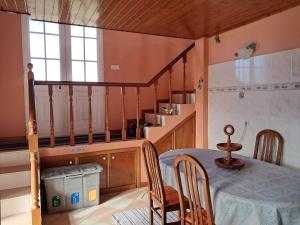 a kitchen with a table and chairs and a staircase at O Chalé das Borboletas in Santa Maria Madalena +2 photos